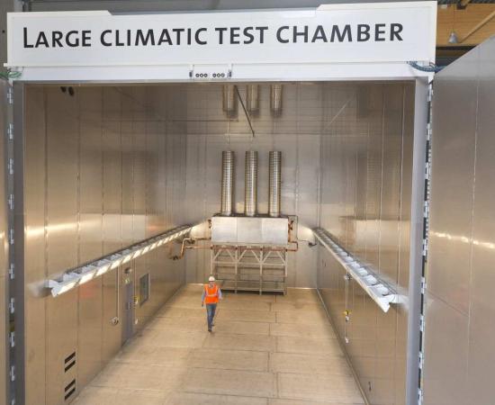 Vue intérieure de la grande chambre d'essais climatiques de Sirris dans le cadre du laboratoire de R&D Harsh, avec un homme pour illustrer la taille de la chambre