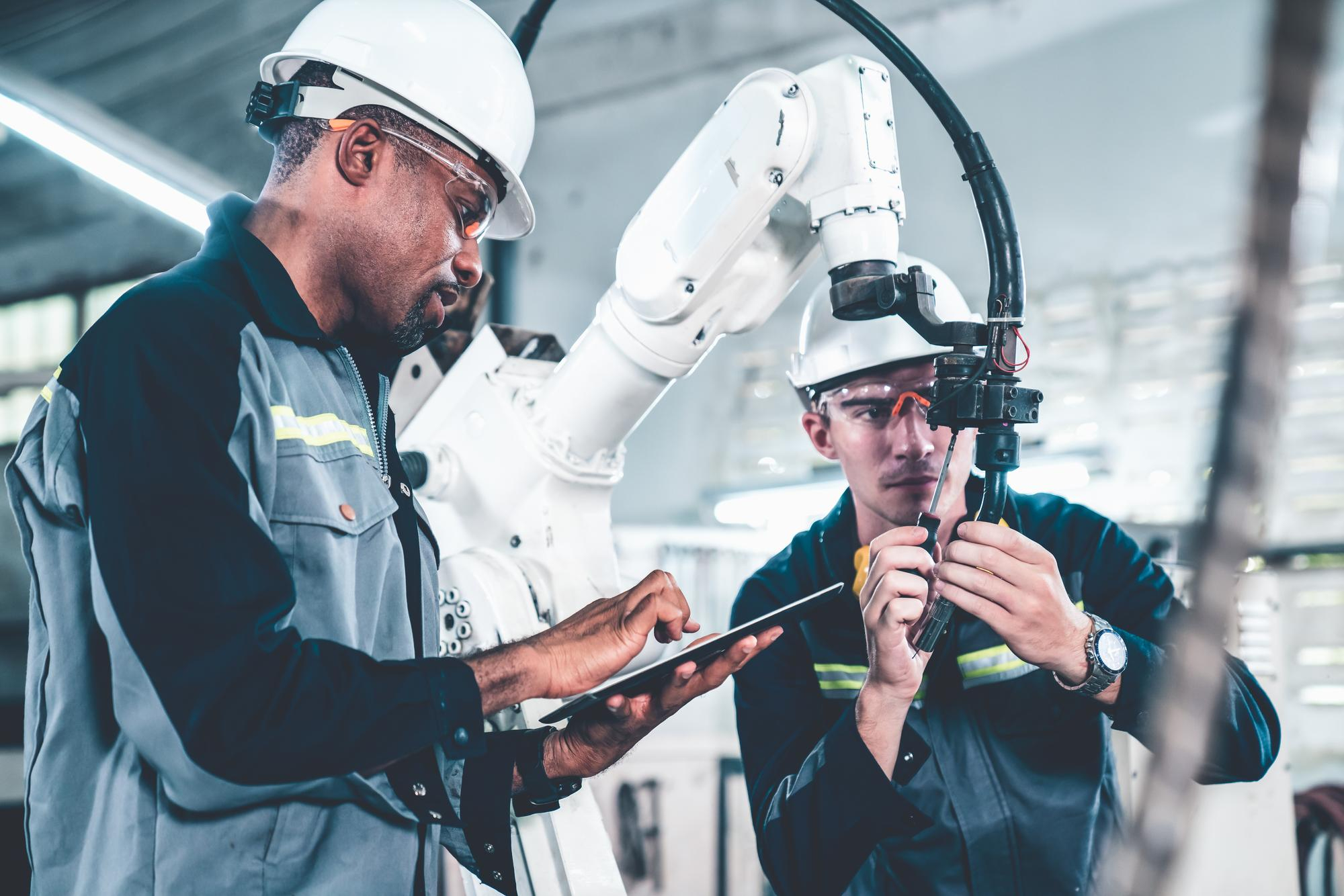 Engineers collecting data while working on robotic arm