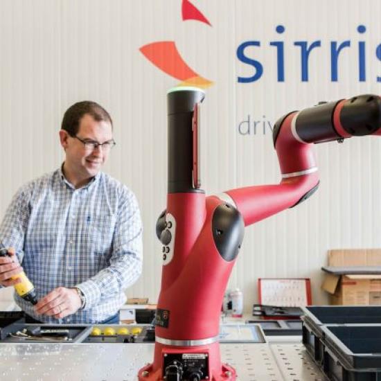 Sirris expert working besides a collaborative industrial robot (cobot) in lab