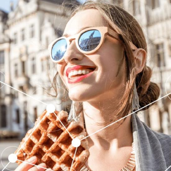 Woman smiling and eating a Belgian waffle on Brussels central square