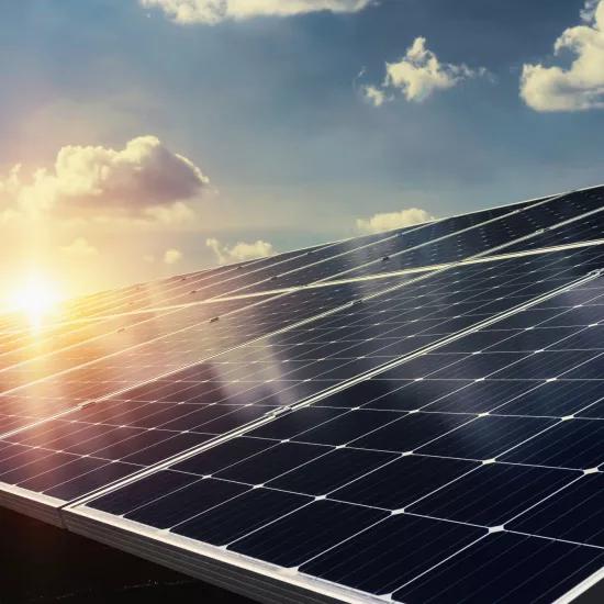 Zonnepanelen onder een blauwe lucht en opkomende zon