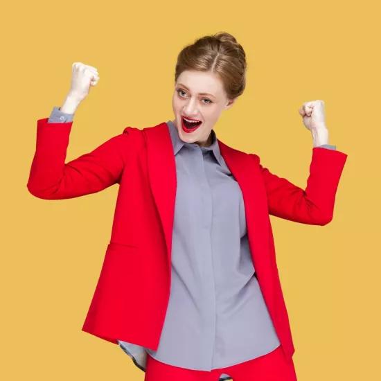 Woman in a red blazer celebrating success, reflecting the theme of successful circular leadership in companies