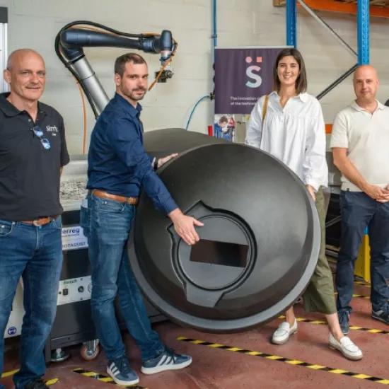 Traflux, Sirris and POM-Limburg standing in front of robotic arm