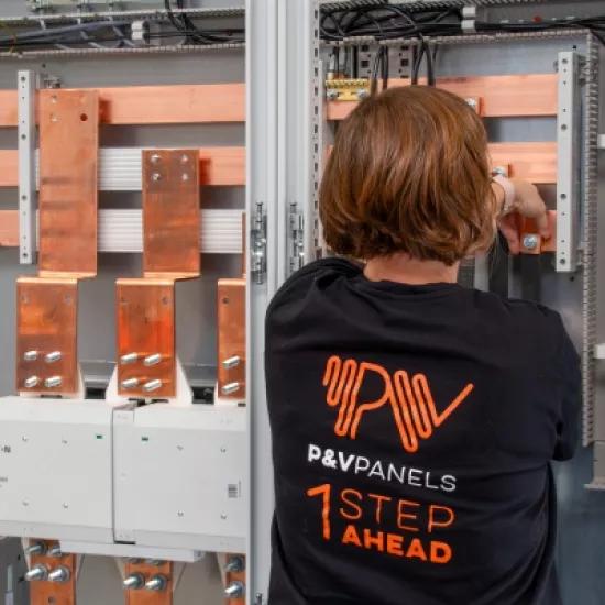 P&V Panels technician assembling an industrial electrical control panel with copper busbars and circuit breakers.*