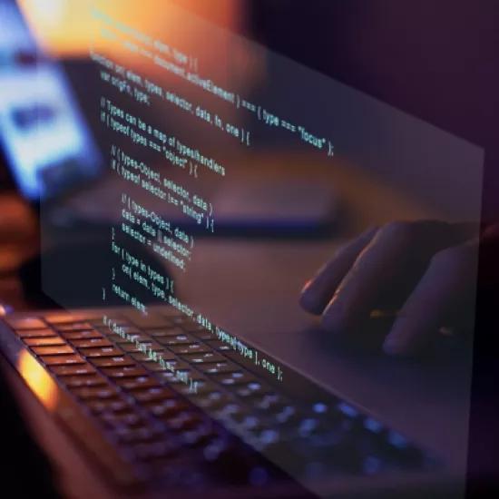 A person vibe coding on a laptop