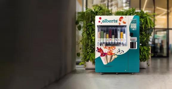 Alberts smart product smoothie vending machine in hallway in front of green plants against wall
