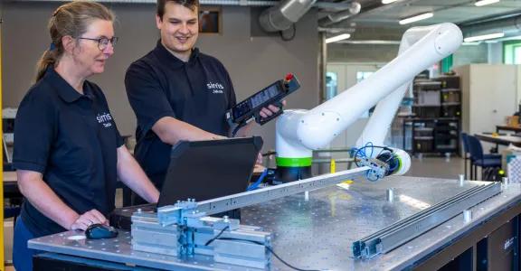 Deux ingénieurs de Sirris testant et instruisant le cobot