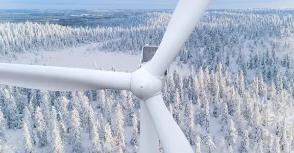 Wind turbine aerial view in snow covered woods in Finland
