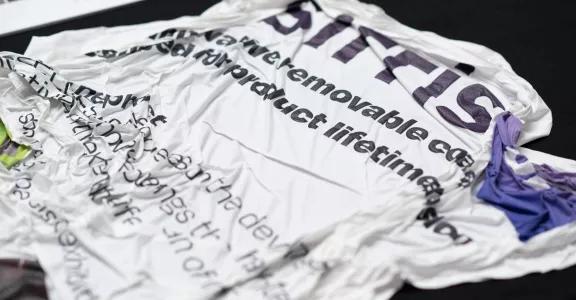 Photo of a crumpled and removed removable coating with textual info on from the Sirris PEELDESIGN research project