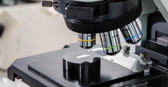 Close-up van een testmonster onder een microscoop in het Sirris Metal Lab, gebruikt voor metallografische analyse.