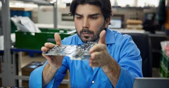 man-worker-is-wearing-blue-shirt-holding-motherboard-his-hands