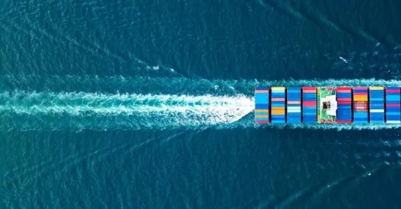 Cargo ship sailing across the sea with containers on board.