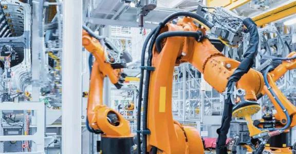Industrial robotic arms operating on an automated automotive production line in a modern manufacturing facility.