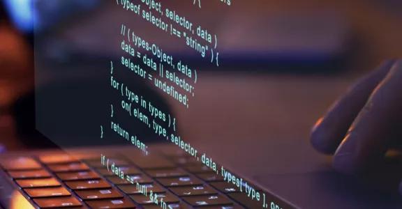 A person vibe coding on a laptop