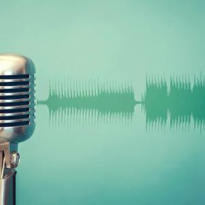Old metal microphone on green background with soundwave illustrating podcast