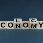 Economy ecology crossspelled with letter cubes on black background